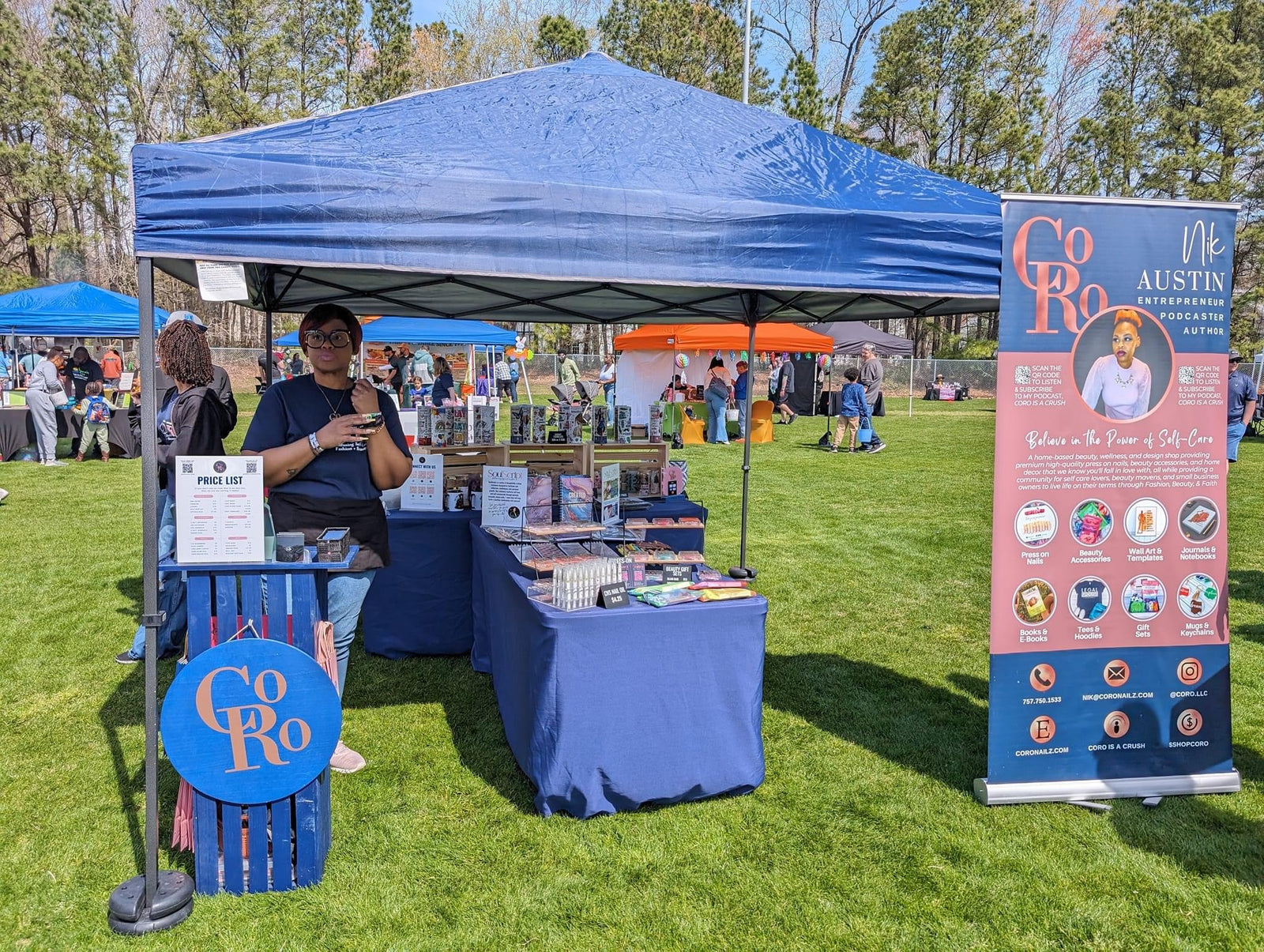 Blue tent with CoRo & Company branding at an outdoor event on a grassy area