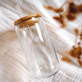 Clear glass tumbler with a wooden lid on a textured surface