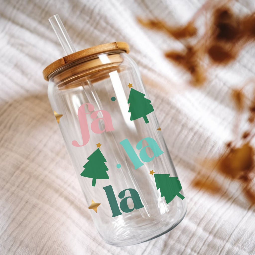 Clear tumbler with 'fa la la' and Christmas tree designs on a textured surface