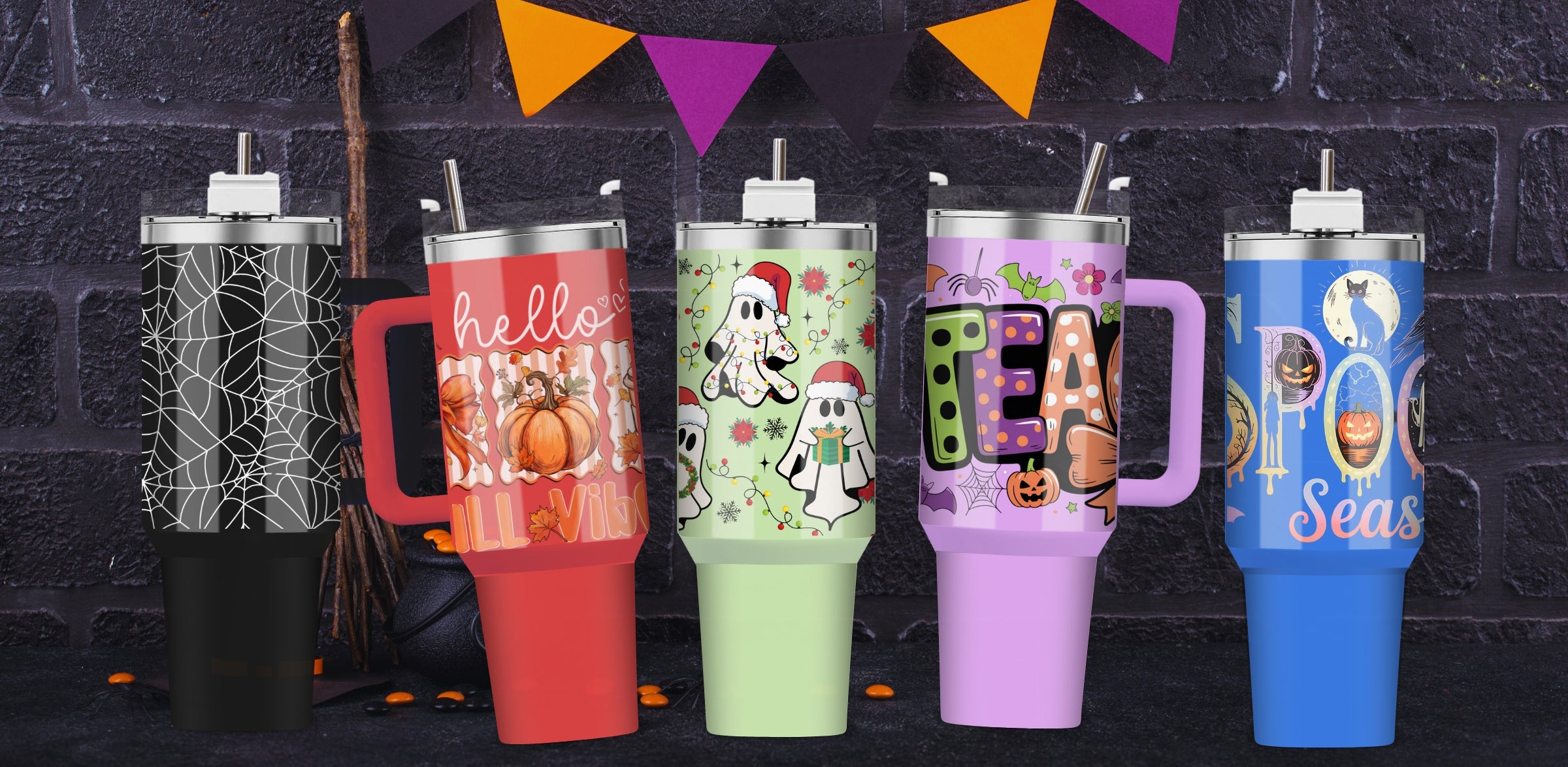 Set of colorful tumblers with Fall, Christmas, and Halloween-themed designs against a dark brick wall.