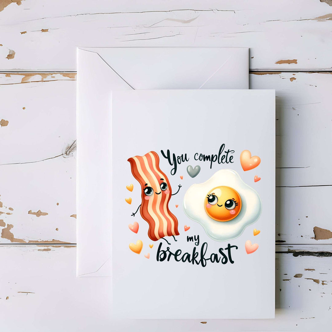 Card with cartoon bacon and egg design on a wooden surface