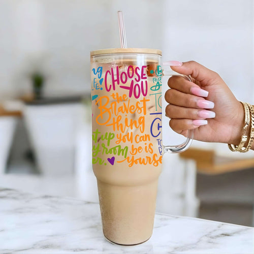 Nik Austin's hand holding a tumbler with motivational quote on a marble surface