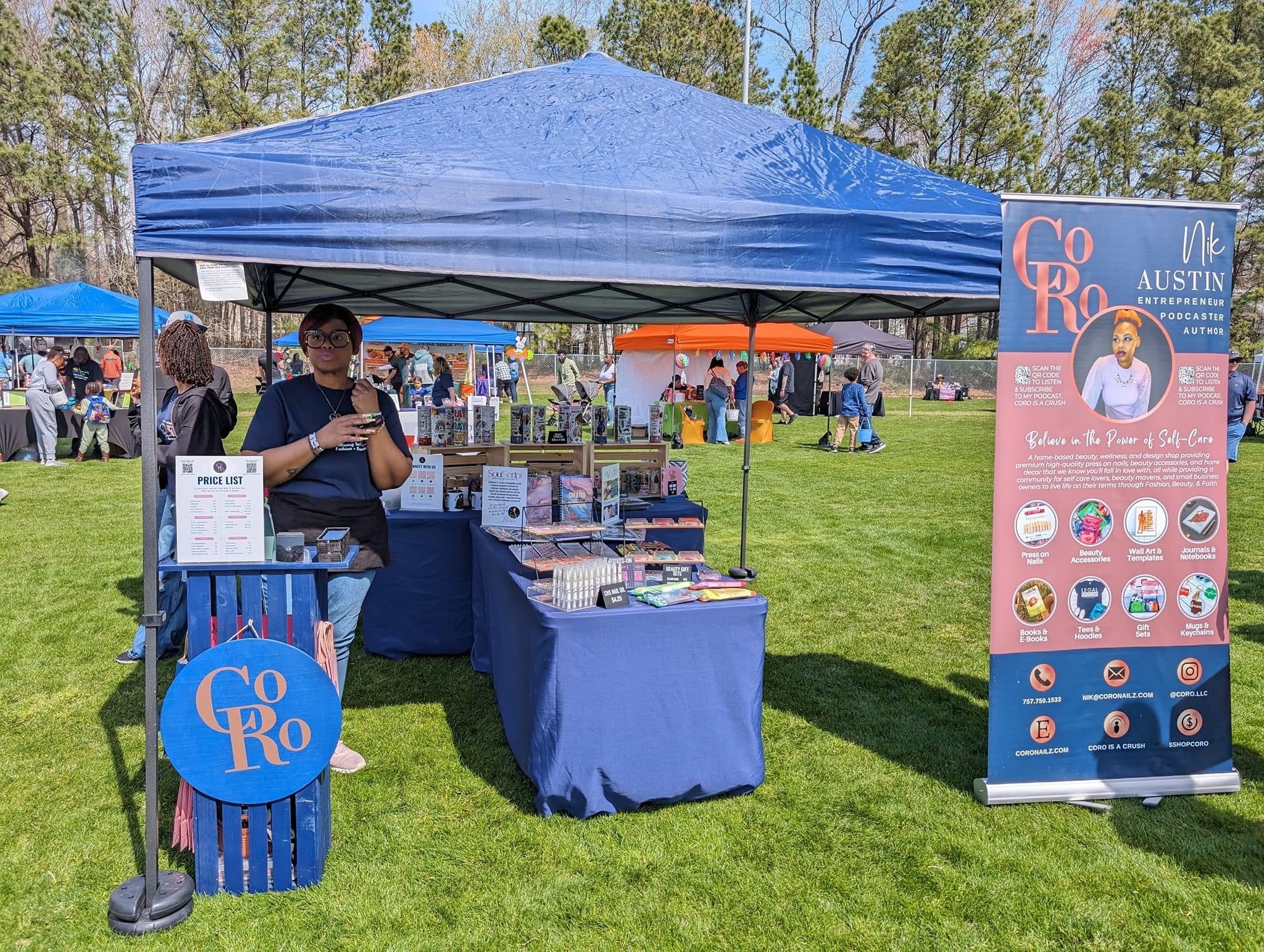 Blue tent with CoRo & Company branding at an outdoor event on a grassy area