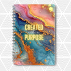 Journal with colorful abstract design and 'Created with a Purpose' text on a white background