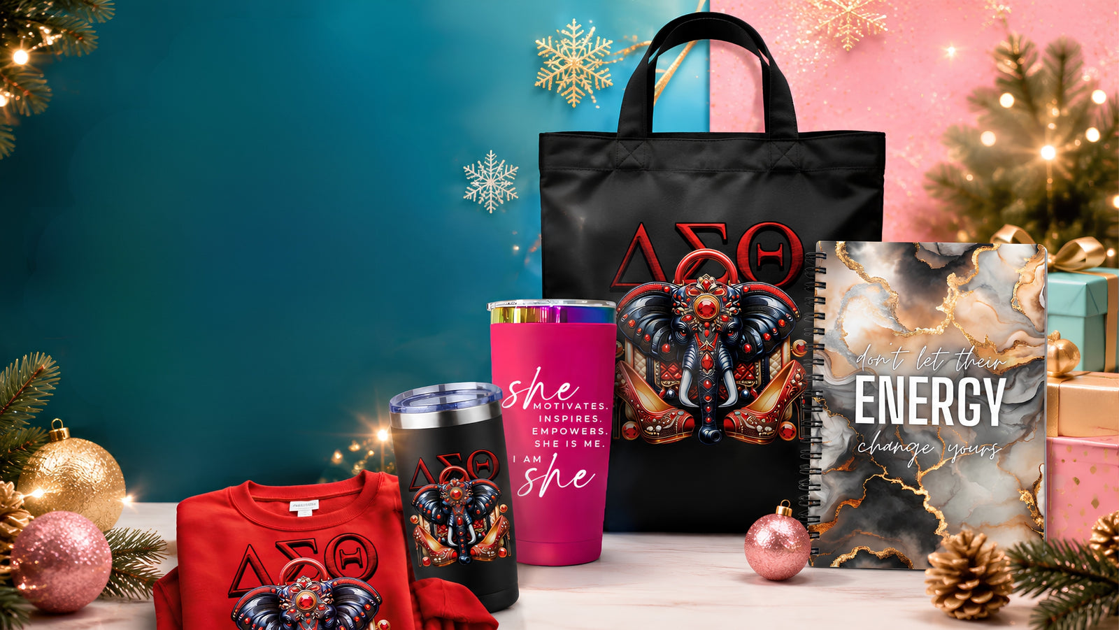A coordinated holiday gift set featuring a black tote bag, a pink tumbler, a red sweatshirt, a black sleeveless top, and a marble-patterned notebook, all printed with festive graphics, arranged on a tabletop with Christmas ornaments, lights, and a teal-to-pink gradient background.
