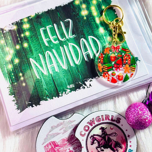 Keychain with festive design on a card with 'Feliz Navidad' text, surrounded by decorative items.