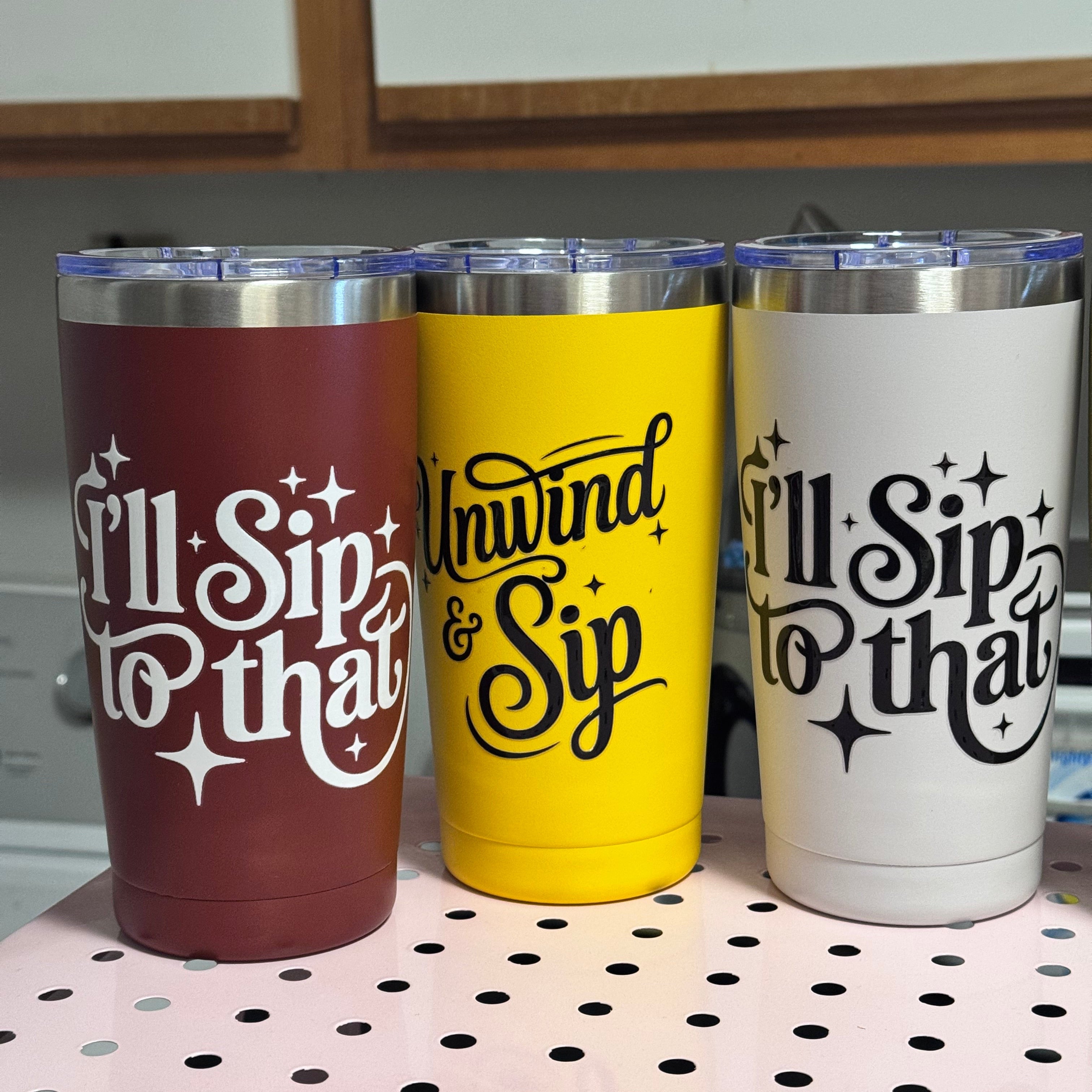 Three tumblers with 'I'll Sip to That' text design on a pegboard.