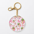 A round acrylic keychain charm featuring a colorful watercolor strawberry and bow pattern, attached to a gold-tone metal split ring and clasp on a plain white background.