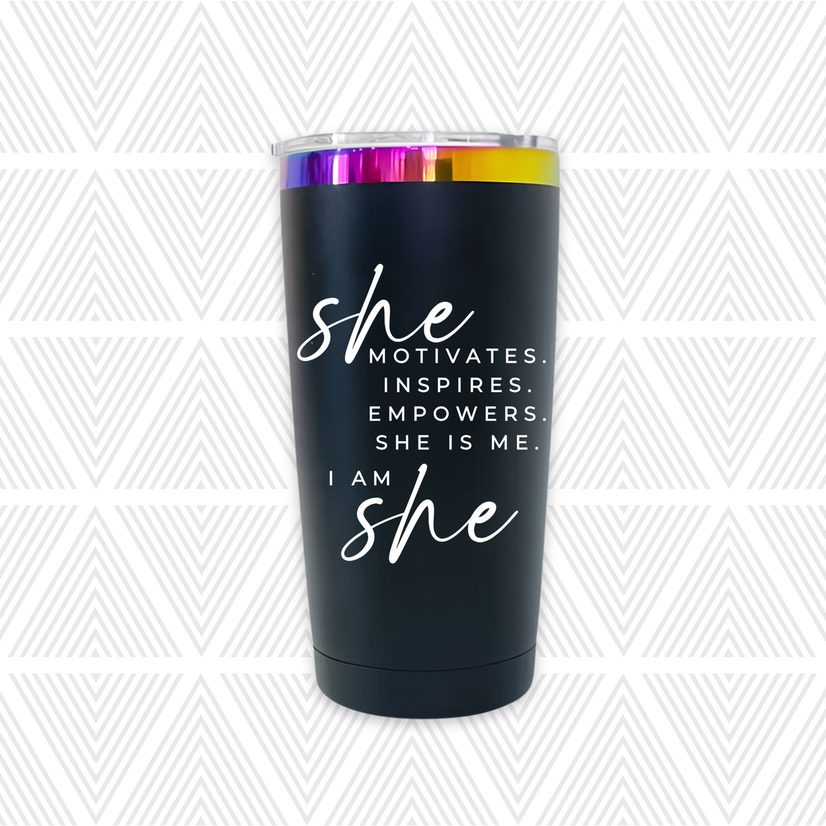 A matte black insulated tumbler with a clear lid and a metallic rainbow rim, featuring the text 'she MOTIVATES. INSPIRES.