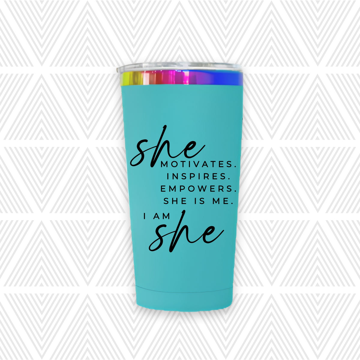 A turquoise insulated tumbler with a clear lid and a rainbow reflective band, featuring the text 'she MOTIVATES. INSPIRES.
