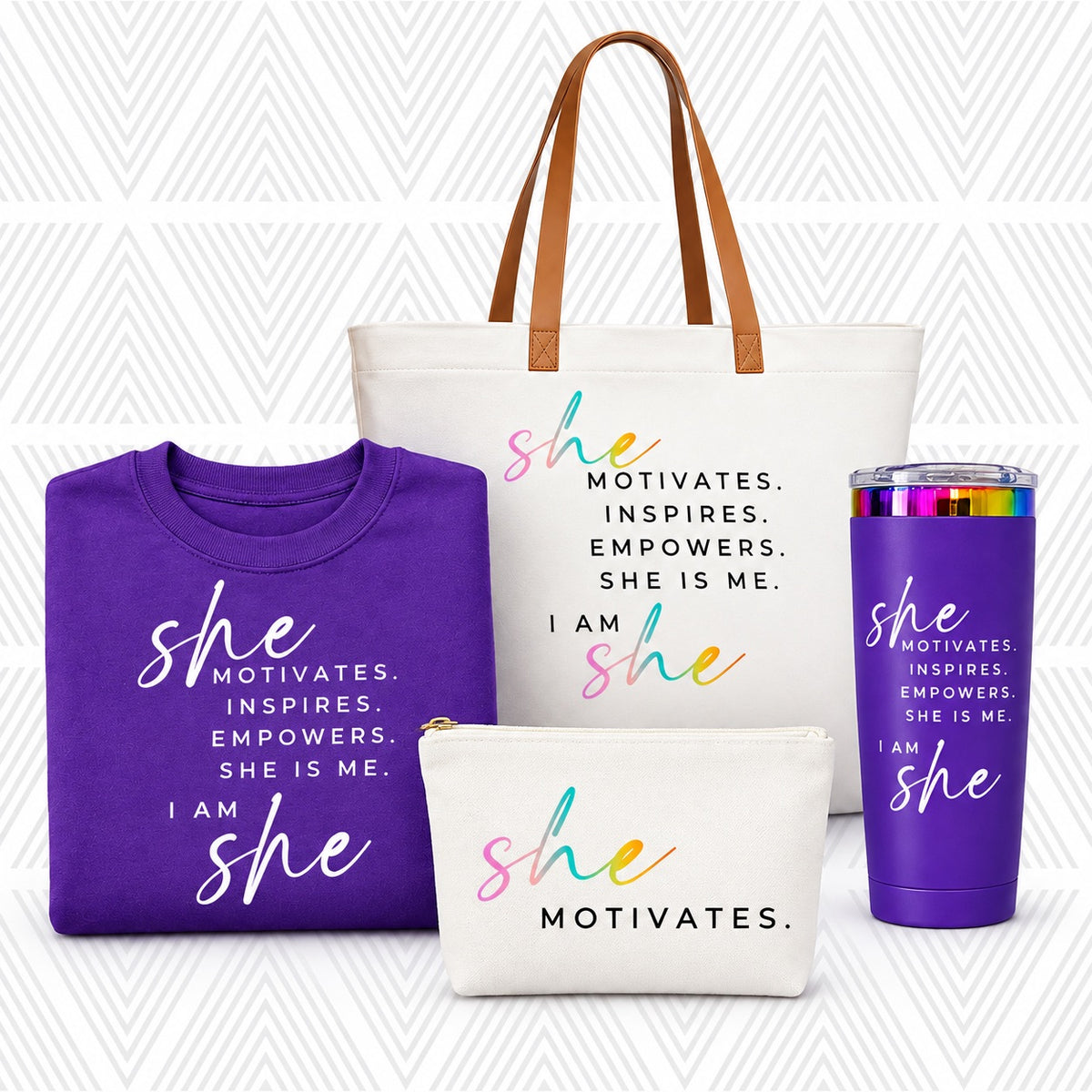 A coordinated gift set featuring a white tote bag with brown handles, a folded purple sweatshirt, a white pouch, and a purple tumbler, all printed with the phrase 'SHE MOTIVATES.'