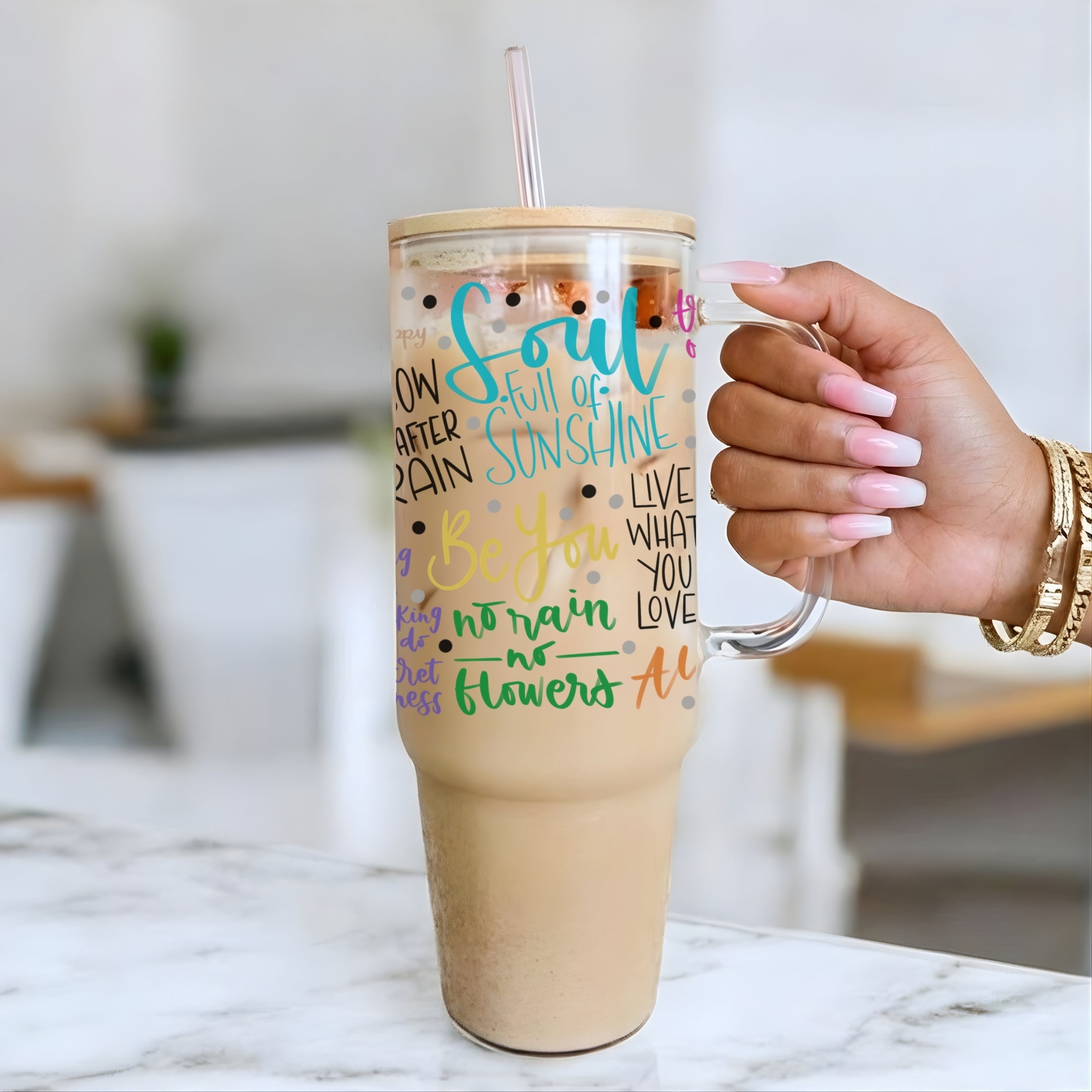 Hand holding a tumbler with Soul Full of Sunshine 40oz glass tumbler on a marble surface.