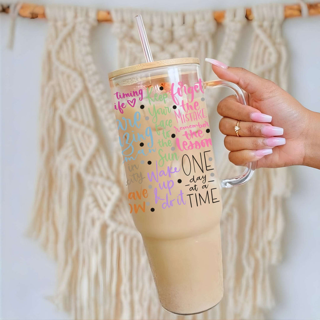 Nik's hand holding a 40oz glass tumbler with Soul Full of Sunshine text against a textured beige background