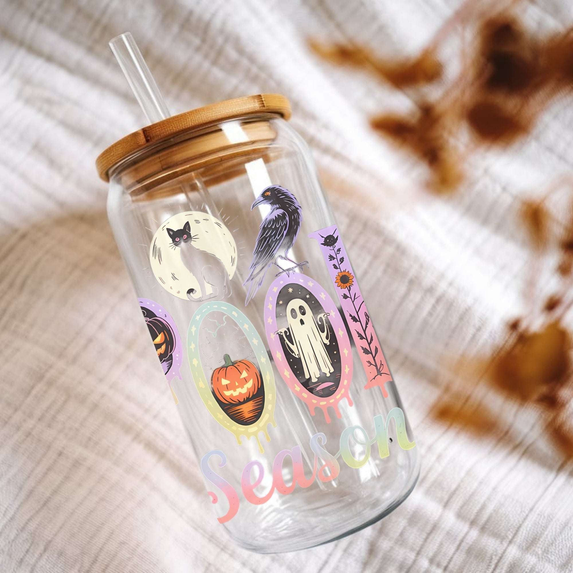 Glass tumbler with Halloween-themed designs and a wooden lid on a textured surface.