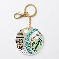 A round acrylic keychain charm with a gold-tone clasp and chain, featuring a pastel multicolor design with text including 'Choose to shine' and 'Tomorrow is a new day' on a light gray background.