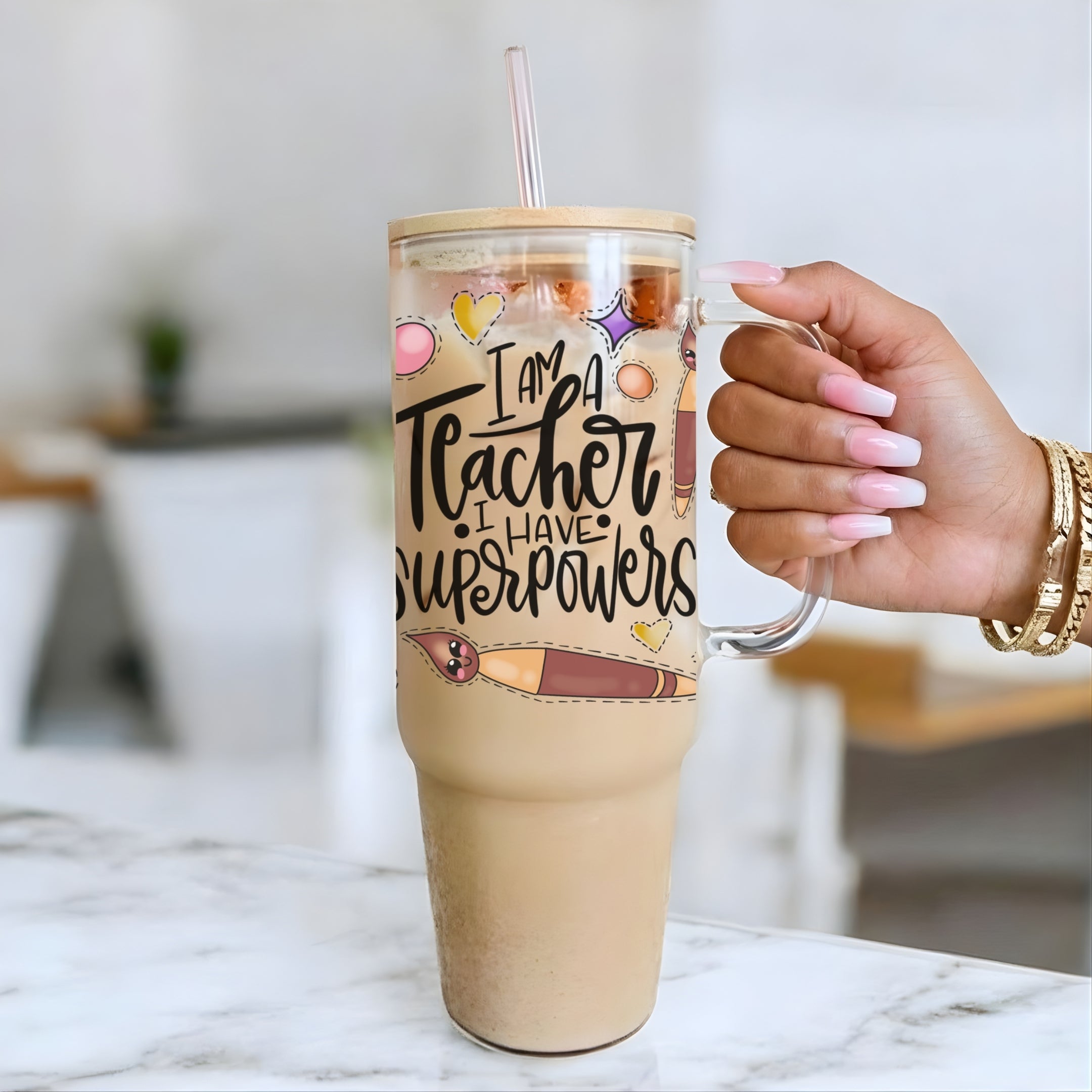 40oz Glass Tumbler with 'I am a Teacher, I have Superpowers' text held by a hand on a marble surface.