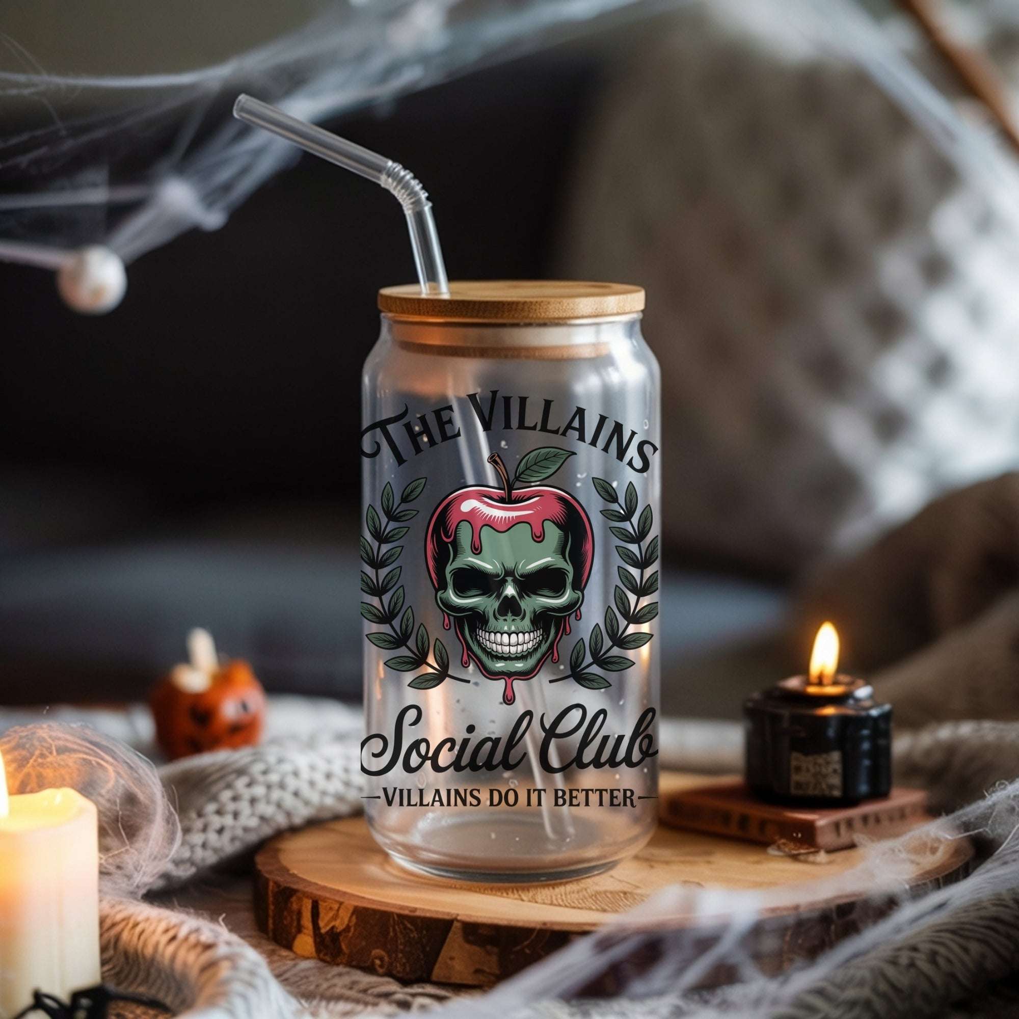 Glass cup with wooden lid and Halloween-themed label on a table with candles and pumpkins.