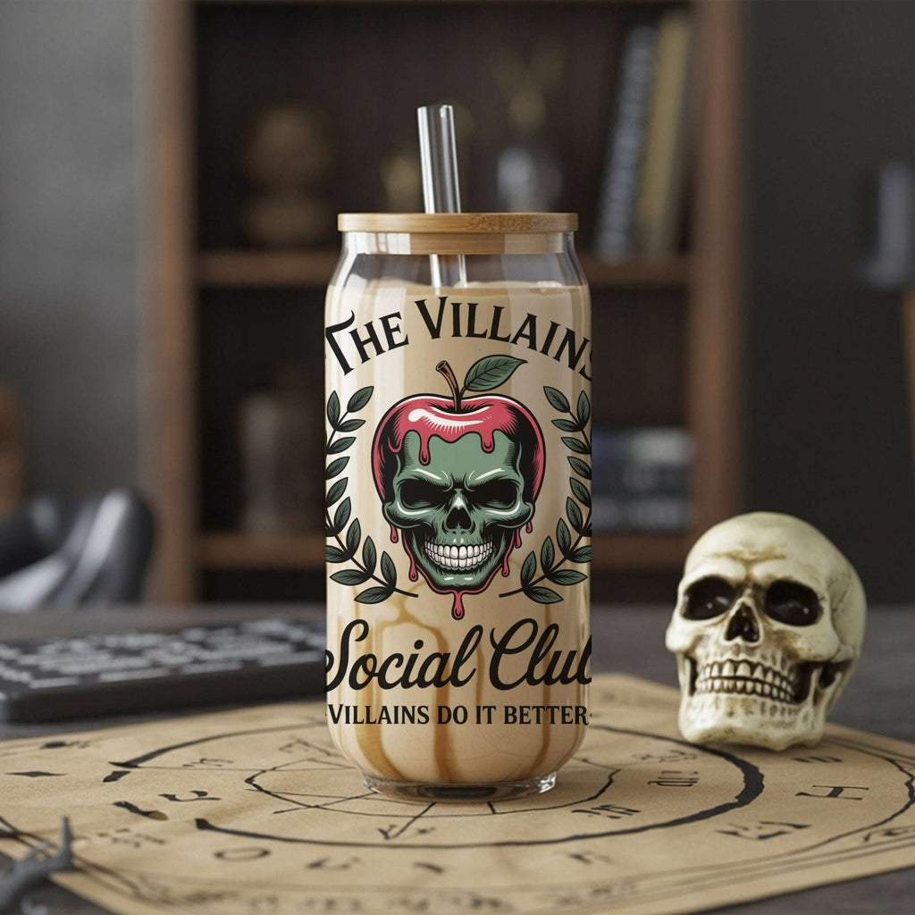 Glass tumbler with skull design and text on a table with a skull and bookshelf in the background