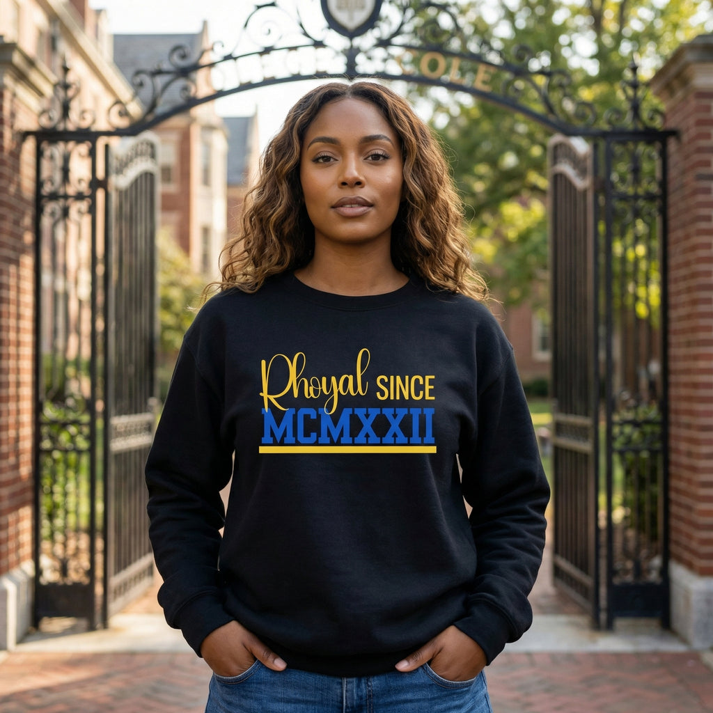 SGRho woman wearing a black sweatshirt with 'Rhoyal Since MCMXXII' text in front of a gate.