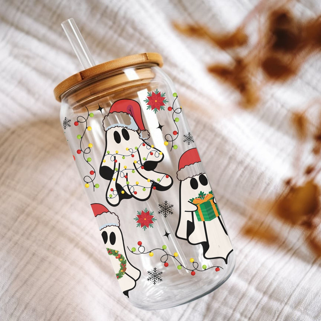 Clear tumbler with Christmas-themed design of ghosts and lights on a textured surface.